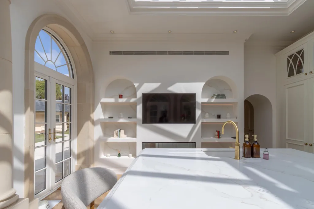 Bespoke kitchen island in a bright orangery extension with arched windows and a glazed lantern roof