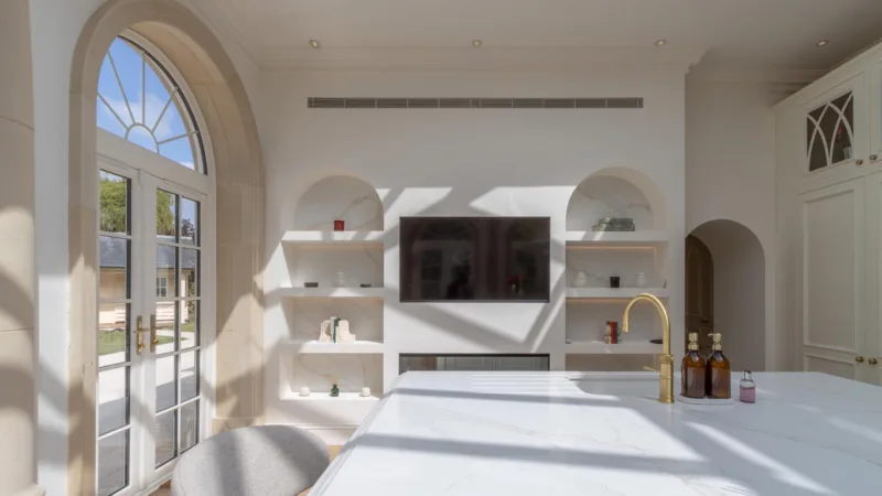 Bespoke kitchen island in a bright orangery extension with arched windows and a glazed lantern roof
