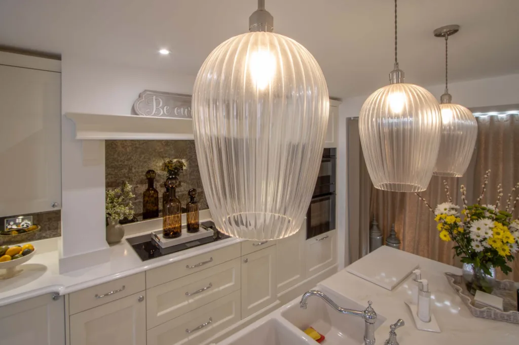 Ribbed glass pendant lights above a classic cream kitchen island