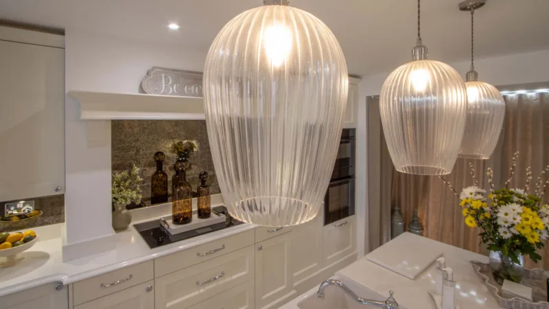 Ribbed glass pendant lights above a classic cream kitchen island