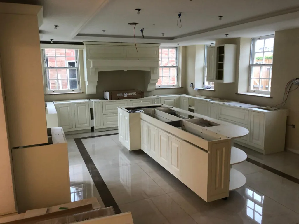 Bespoke kitchen part-way through installation, with the island and cabinetry in place before worktops are fitted